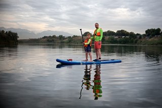 father-and-his-son-are-standing-on-the-sup-board-2022-11-10-18-24-09-utc