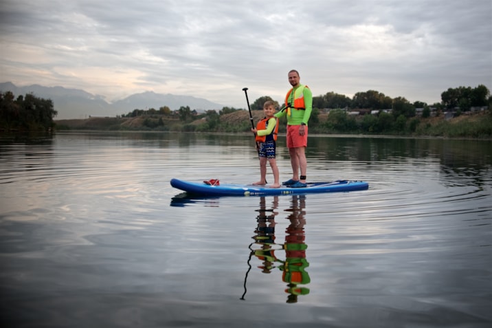 father-and-his-son-are-standing-on-the-sup-board-2022-11-10-18-24-09-utc